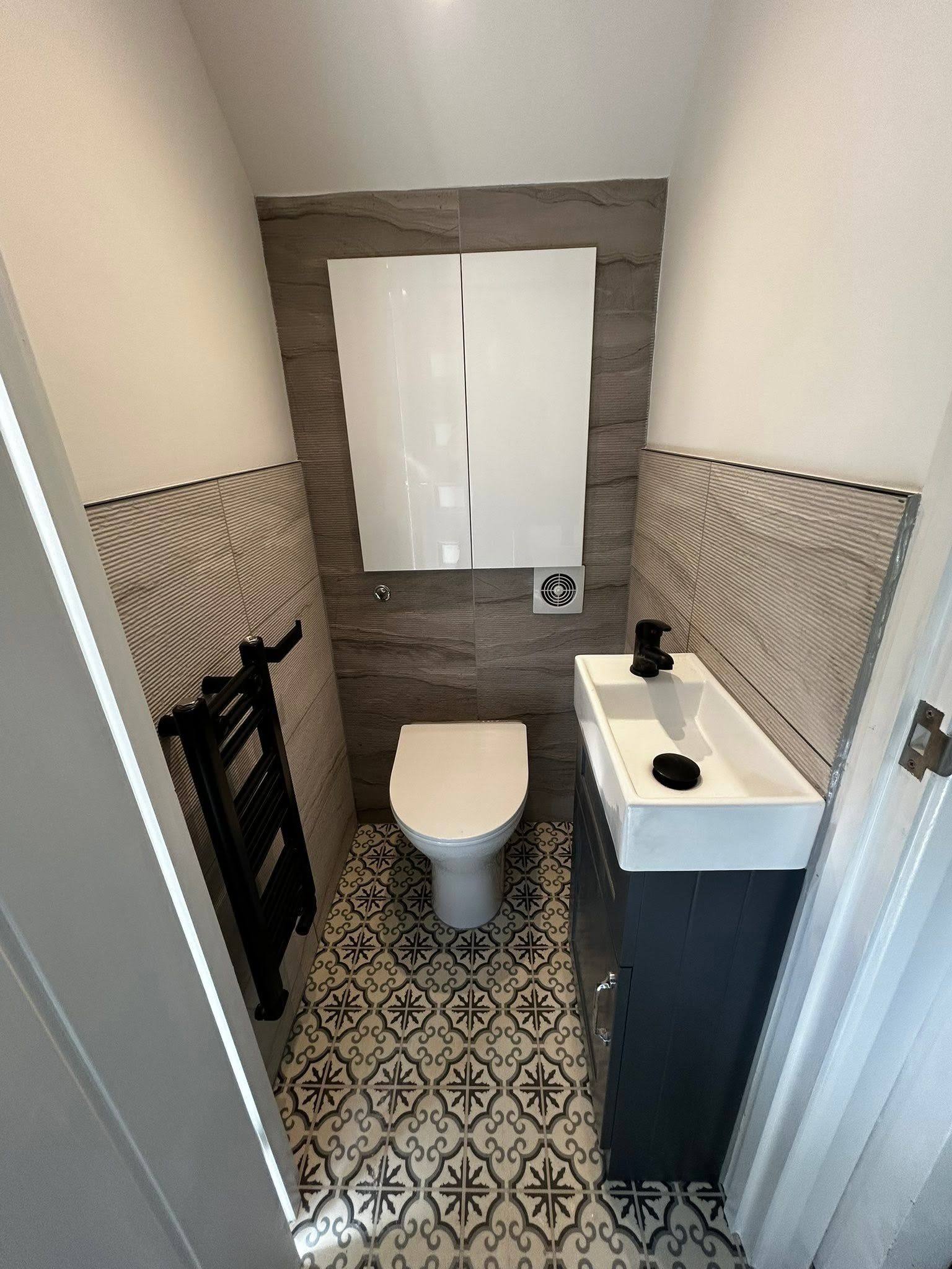 Small downstairs cloakroom with patterned floor tiles