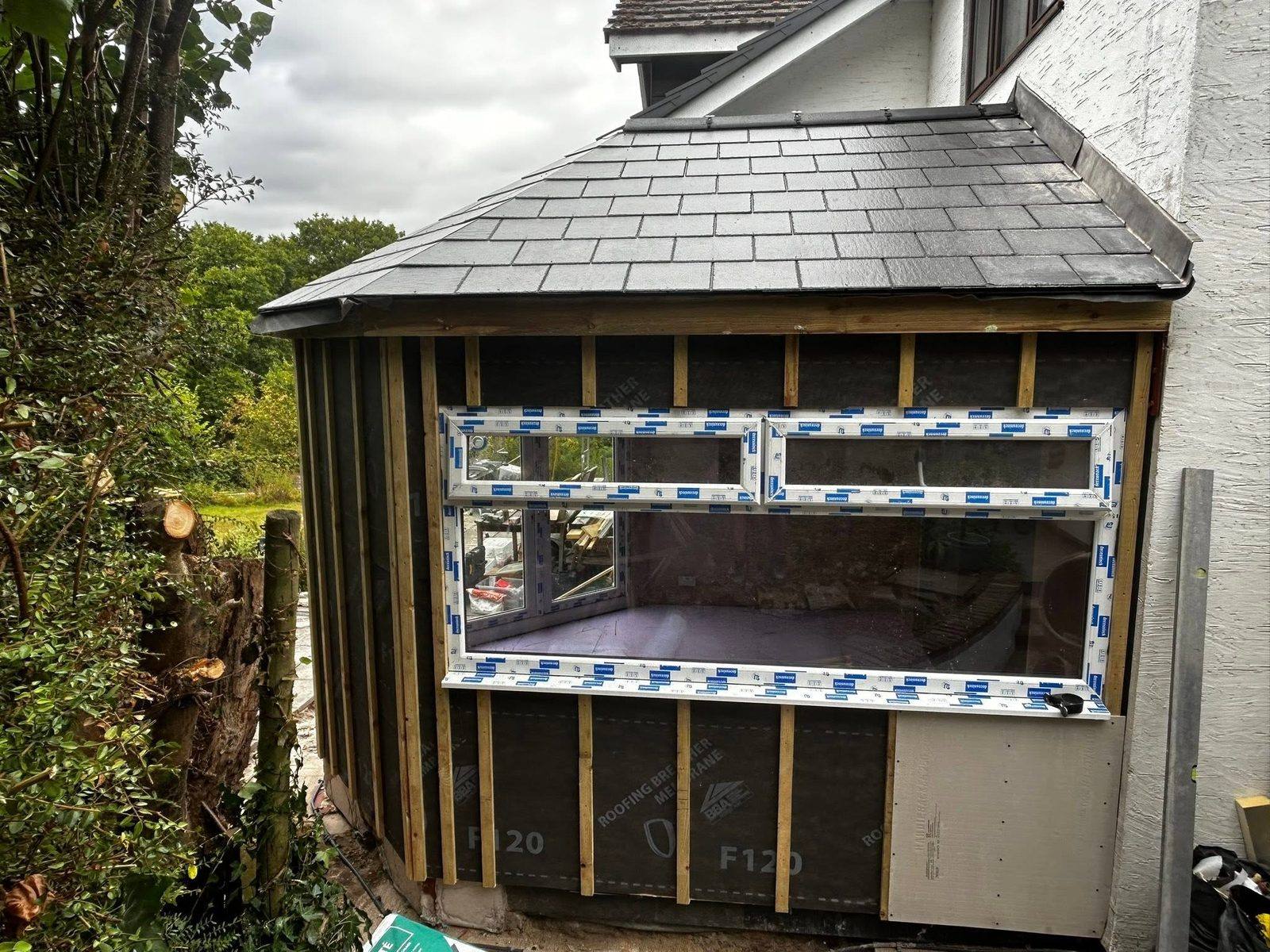 New solid slate roof framed onto conservatory conversion