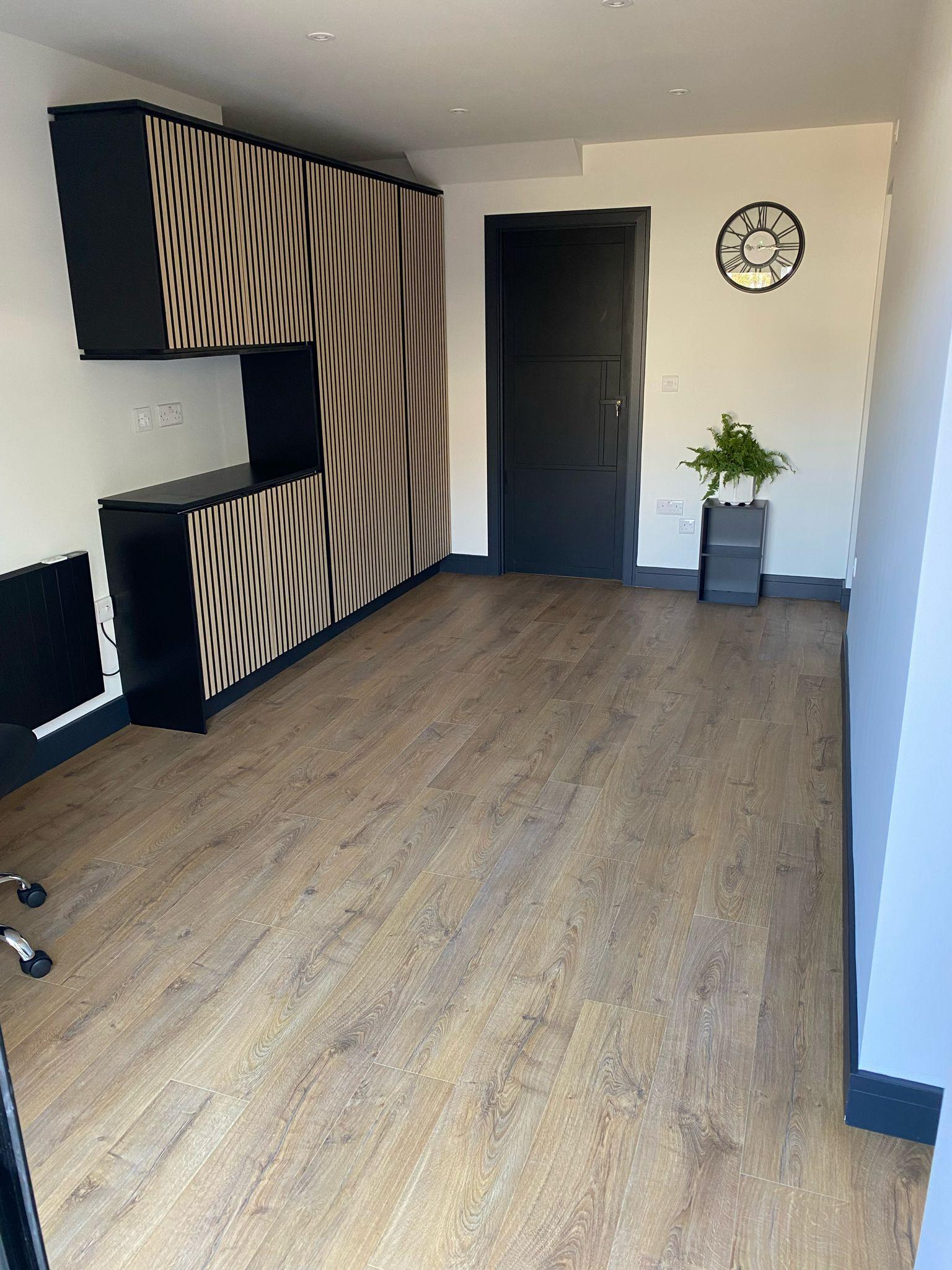 Modern living room with slatted oak media wall and engineered oak floor